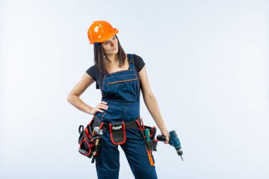 Evde çalışma için matkap ve bazı güç araçlarını kullanarak toolbelt olan kadın. Düz beyaz arka plan üzerinde remodeling çalışan kız. Bina, onarım ve yenileme.