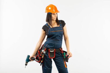 Evde çalışma için matkap ve bazı güç araçlarını kullanarak toolbelt olan kadın. Düz beyaz arka plan üzerinde remodeling çalışan kız. Bina, onarım ve yenileme.