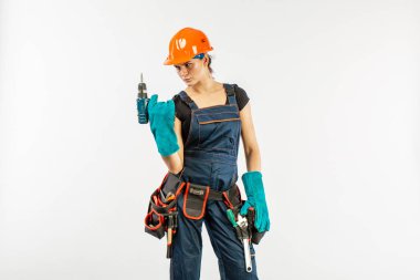 Tulum ve kask elektrik tutan alet kemeri ile seksi workwoman matkap, beyaz arka plan üzerinde. Kaynak eldiven giyen Oluşturucusu kadın