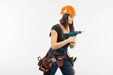 Evde çalışma için matkap ve bazı güç araçlarını kullanarak toolbelt olan kadın. Düz beyaz arka plan üzerinde remodeling çalışan kız. Bina, onarım ve yenileme.