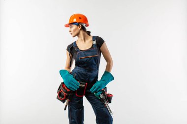 İnşaat iş ve ev geliştirme işleri kavramı ile kask veya kask, alet kemeri ve diğer güvenlik ekipmanları beyaz arka plan üzerinde giyen beyaz esmer olgun kadın