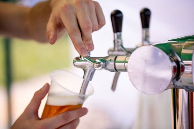 bira barmen el Close-up dokunun tek kullanımlık bir bardak fıçı bira bira dökme