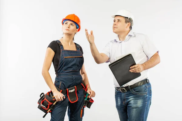 contractors people discussing the plan of building over white background. Foreman with builder woman wearing helmets.