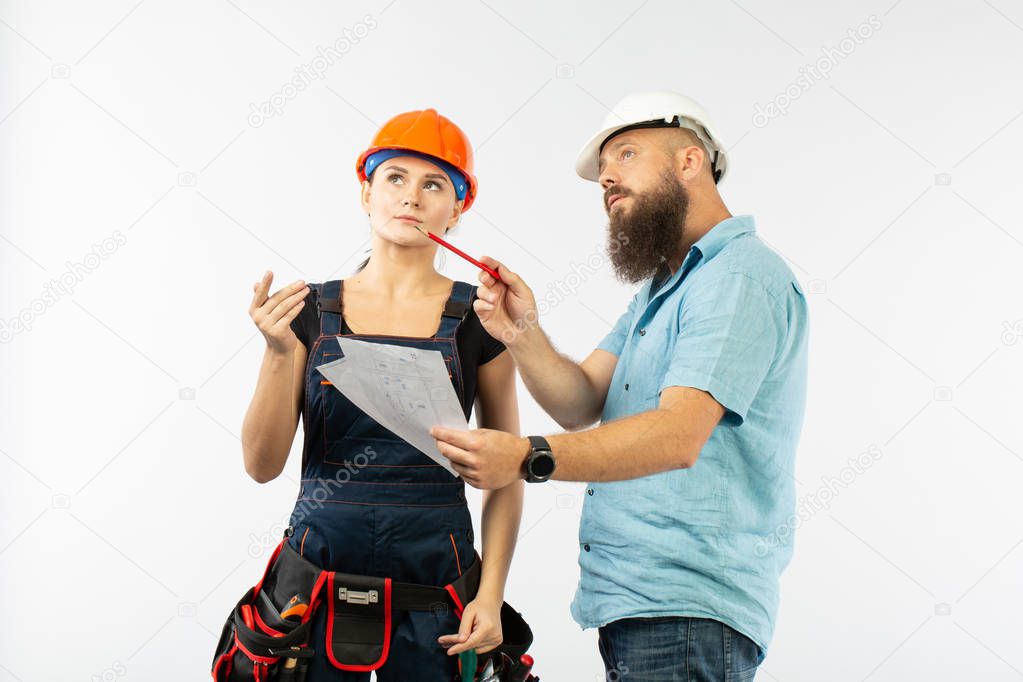 A male architect or engineer meeting with a building woman contractor on white background. The process of discussimg the plam of building. Bisiness concept. dimensioning