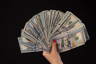 Kadın el yüz dolar faturaları üzerinde siyah bir arka plan ile. yeni ve eski banknotlar