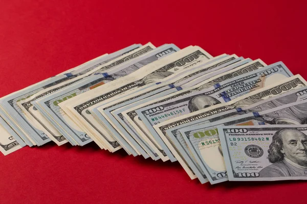 Stack of one hundred dollar bills new and old design on red background. casino bet