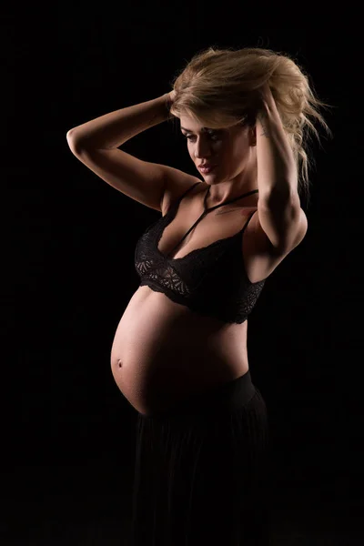 Portrait of a pregnant woman in a dark background — Stock Photo, Image