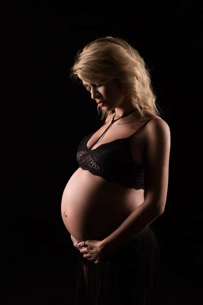 Portrett av en gravid kvinne i mørk bakgrunn – stockfoto
