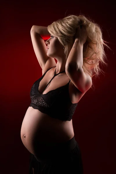 Ritratto di una donna incinta in uno sfondo scuro — Foto Stock