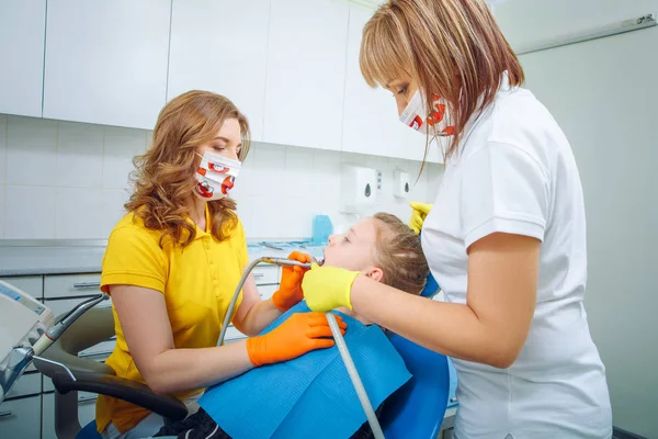 Изображение стоматологического осмотра, которое дал маленькой девочке стоматолог с ассистентом рядом — стоковое фото