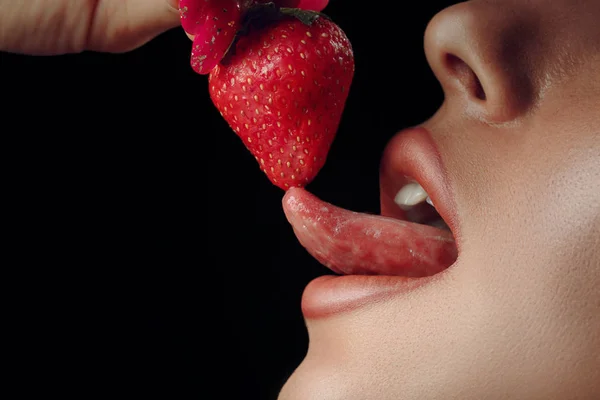 Sexy image of red lips kissing strawberry. Passion and desire. Perfect skin. Royalty Free Stock Images
