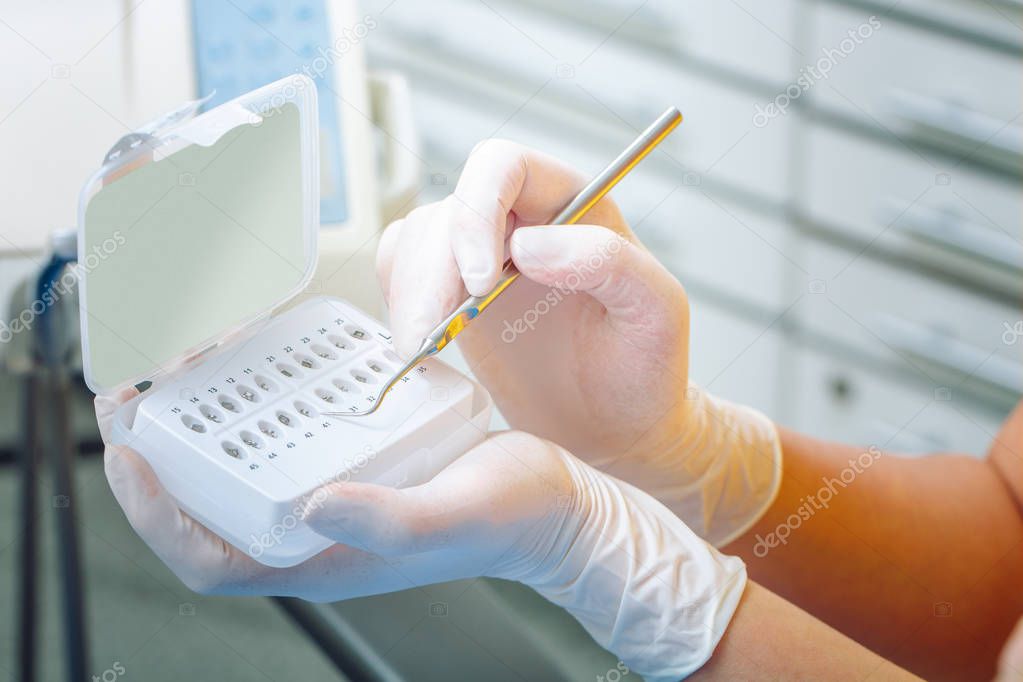 Dental concept. Braces for teeth close up. Dentist takes the lock for the bracket from the set