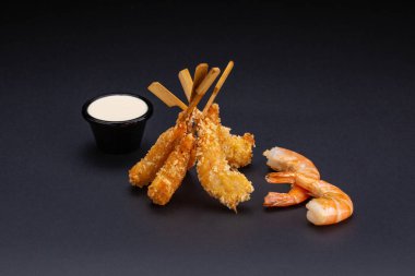 Kaplan karides meyilli içinde. Ebi tempura koyu arka plan üzerinde baharatlı sos ile. Kızarmış karides