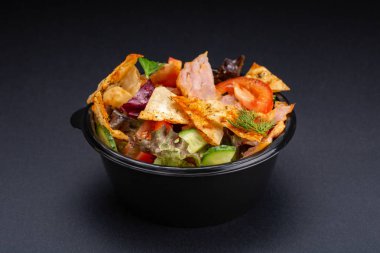 Siyah arka plan üzerine karışımı salata servis. Restoran yemek kavramı. Restoran - salata domates, roka, salata, peynir, badem cips, radicchio, kızarmış et ile çanak.