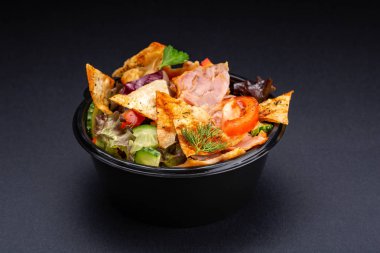 Siyah arka plan üzerine karışımı salata servis. Restoran yemek kavramı. Restoran - salata domates, roka, salata, peynir, badem cips, radicchio, kızarmış et ile çanak.