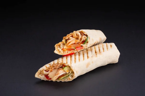 Shawarma sandviç - taze rulo ince lavaş veya pide ekmek ızgara et, mantar, peynir, lahana, havuç, sosu, yeşil ile dolu. Geleneksel Doğu Aperatif. Siyah bir arka plan üzerinde.