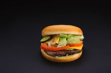 siyah arka plan üzerinde sığır eti ile lezzetli burger.