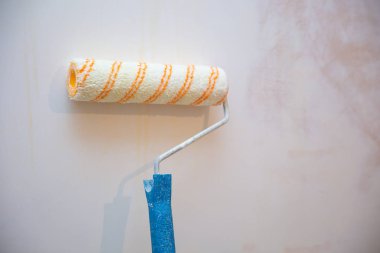 Bir duvar boya silindiri ile boyama ressam kolu yakın çekim