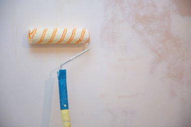 Bir duvar boya silindiri ile boyama ressam kolu yakın çekim