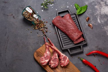 Baharat Chesno kemikte et çiğ taze koyun eti ve siyah bir zemin üzerine biberiye