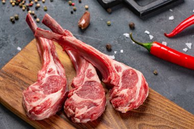 Çiğ et taze otlar ve baharatlar, kemikte kopya alanı, üstten görünüm ile yemek pişirmek için siyah arka plan.