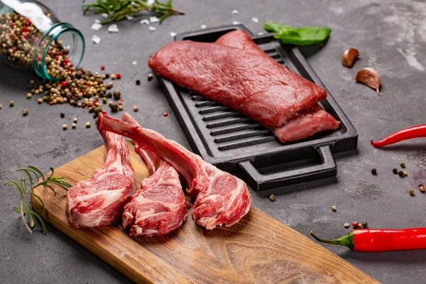Set van rauwe ongekookte black angus rundvlees tomahawk steaks op beenderen en kalfsvlees varkenshaas geserveerd met Chili en peper. Rustieke stijl. — Stockfoto