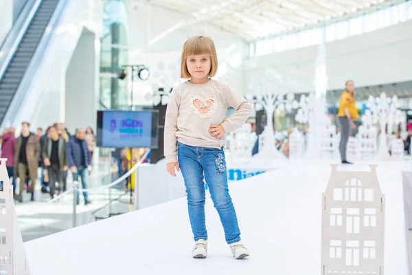 Kiev, Ukraina mars 03.2019. Ukfw. Ukrainska barn mode dag. Lilla blonda flickan bär på casual stil poserar på pallen — Stockfoto