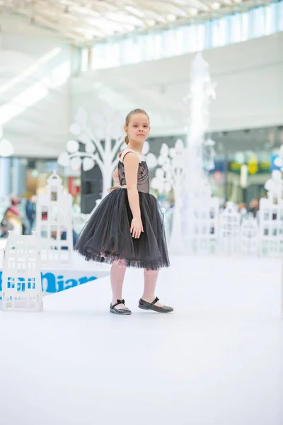 Kiev, Ucrania marzo 03.2019. UKFW. Día de la moda de niños ucranianos. Pequeña modelo de niña vestida de negro posando en el podio — Foto de Stock