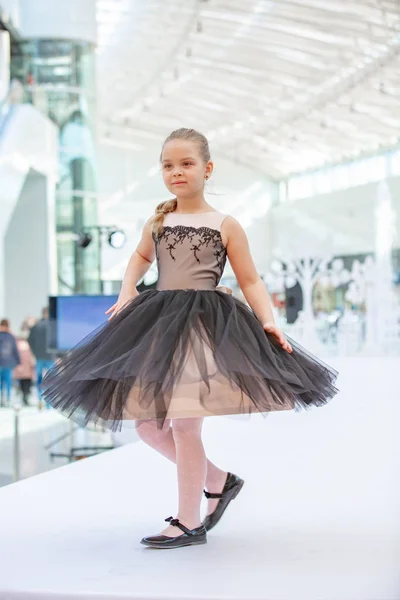 Kiev, Ucrania marzo 03.2019. UKFW. Día de la moda de niños ucranianos. Pequeña modelo de niña vestida de negro posando en el podio — Foto de Stock