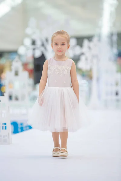 Kiev, Ucrania marzo 03.2019. UKFW. Día de la moda de niños ucranianos. Pequeña modelo de niña vestida con vestido pastel posando en el podio — Foto de Stock