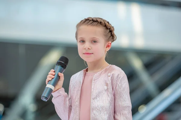 Kiev, Ukraina mars 03.2019. Ukfw. Ukrainska barn mode dag. Flickan håller mikrofonen i handen medan du utför låt vid evenemanget — Stockfoto