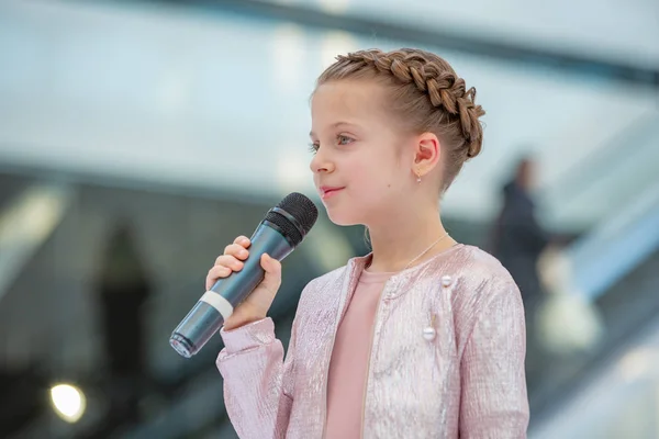 Kiev, Ukraina mars 03.2019. Ukfw. Ukrainska barn mode dag. Flickan håller mikrofonen i handen medan du utför låt vid evenemanget — Stockfoto