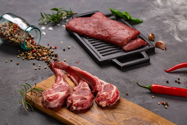 Set van rauwe ongekookte black angus rundvlees tomahawk steaks op beenderen en kalfsvlees varkenshaas geserveerd met Chili en peper. Rustieke stijl. — Stockfoto