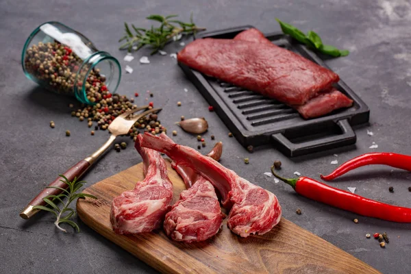 Set van rauwe ongekookte black angus rundvlees tomahawk steaks op beenderen en kalfsvlees varkenshaas geserveerd met Chili en peper. Rustieke stijl. — Stockfoto