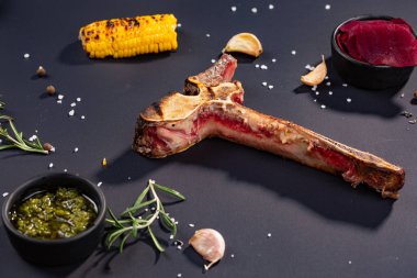 Gurme Grill Restoran biftek menü - siyah arka plan üzerine yenmiş T-Bone biftek biftek. Kara Angus Başbakan sığır eti biftek. Sığır eti biftek yemek. ızgarada Mısır, sarımsak, biberiye, soslar ile boğumlu kemik