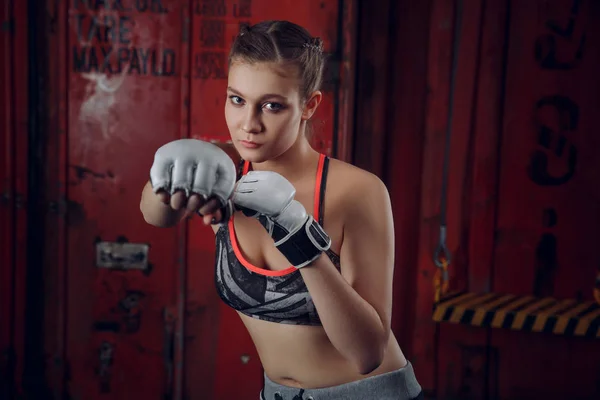 Boxer MMA female fighter posing in confident defensive stance with gloves up