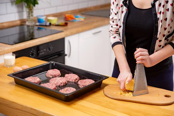 Кулинария, еда и домашняя концепция - крупный план женских рук, терющих сыр — стоковое фото