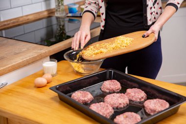 Kesme tahtası rendelenmiş peynir plaka ile dökme el. Beşamel sos veya köfte pişirme işlemi.