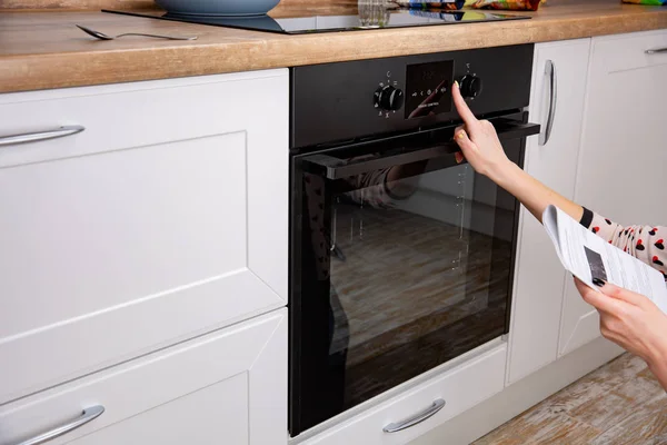 Femeia reglează modul de gătit pe panoul cuptorului — Fotografie, imagine de stoc