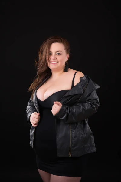 Bella giovane donna plus size con grande busto in biancheria intima e giacca di pelle n sfondo nero — Foto Stock