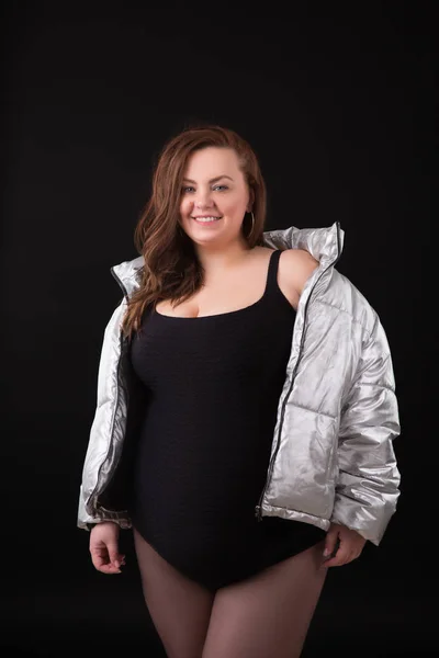 Beautiful young woman plus size with big bust in underwear and down jacket