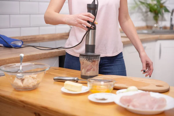 Frau verwendet einen Stabmixer, um eine Pastete zuzubereiten — Stockfoto