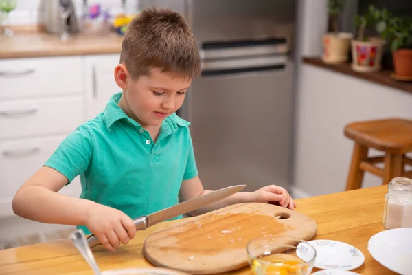 Little baby boy is reaching kitchen knife - danger in kitchen