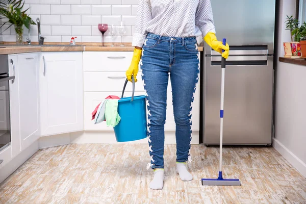 Vrouw met dweil en emmer met schoonmaakmiddelen thuis — Stockfoto