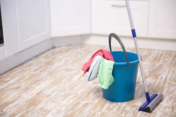 Plastic bucket with cleaning supplies in home — Stock Photo, Image