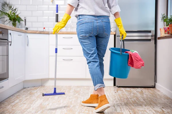 Vrouw met dweil en emmer met schoonmaakmiddelen thuis — Stockfoto