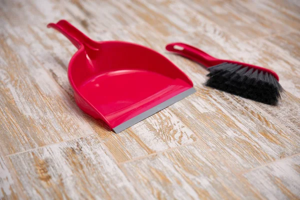 Besen und Schaufel auf Holzuntergrund. Kunststoff-Ausrüstung für die Reinigung — Stockfoto