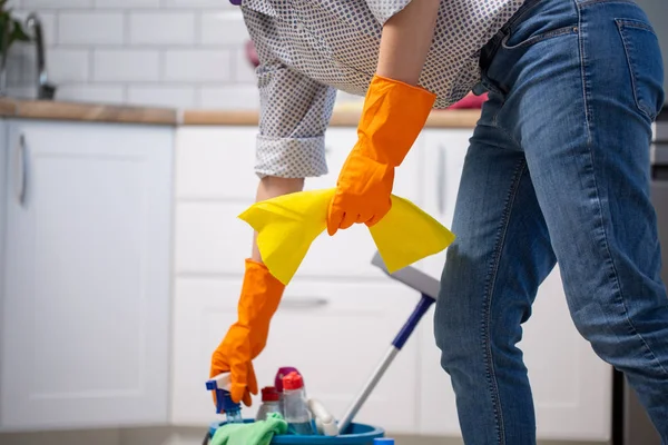 Vrouwelijke huishoudster tijdens het schoonmaken van kantoor. Vrouw dragen van beschermende handschoenen in de buurt van emmer vol met schoonmaakproducten — Stockfoto