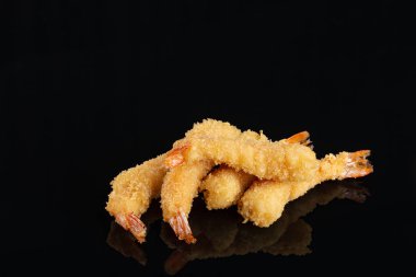 Fried Shrimps tempura in black plate on dark concrete surface background. Seafood tempura dish clipart