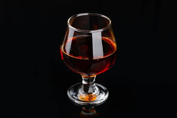 Glass of brandy on a black background — Stock Photo, Image